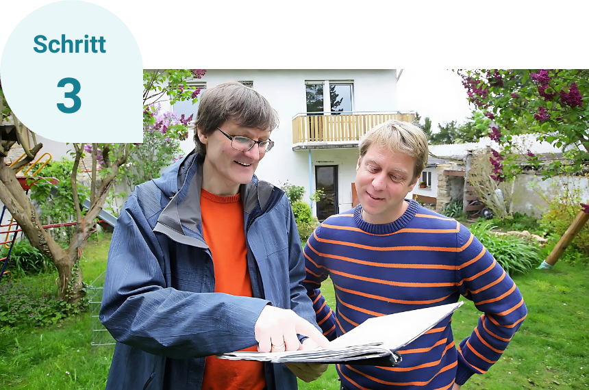 Schritt 3: Vor einem Haus im Garten stehen zwei Männer, die sich unterhalten. Sie gucken sich Papierunterlagen an.