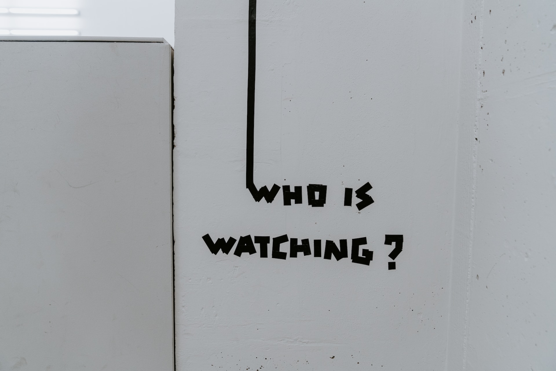 Weiße Wand mit dem Schriftzug "Who is watching?"
