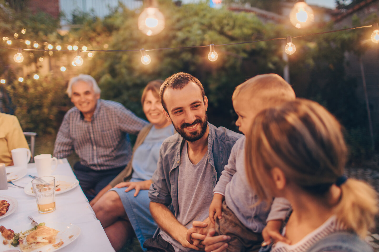 Familienessen im Freien mit Lichtern.