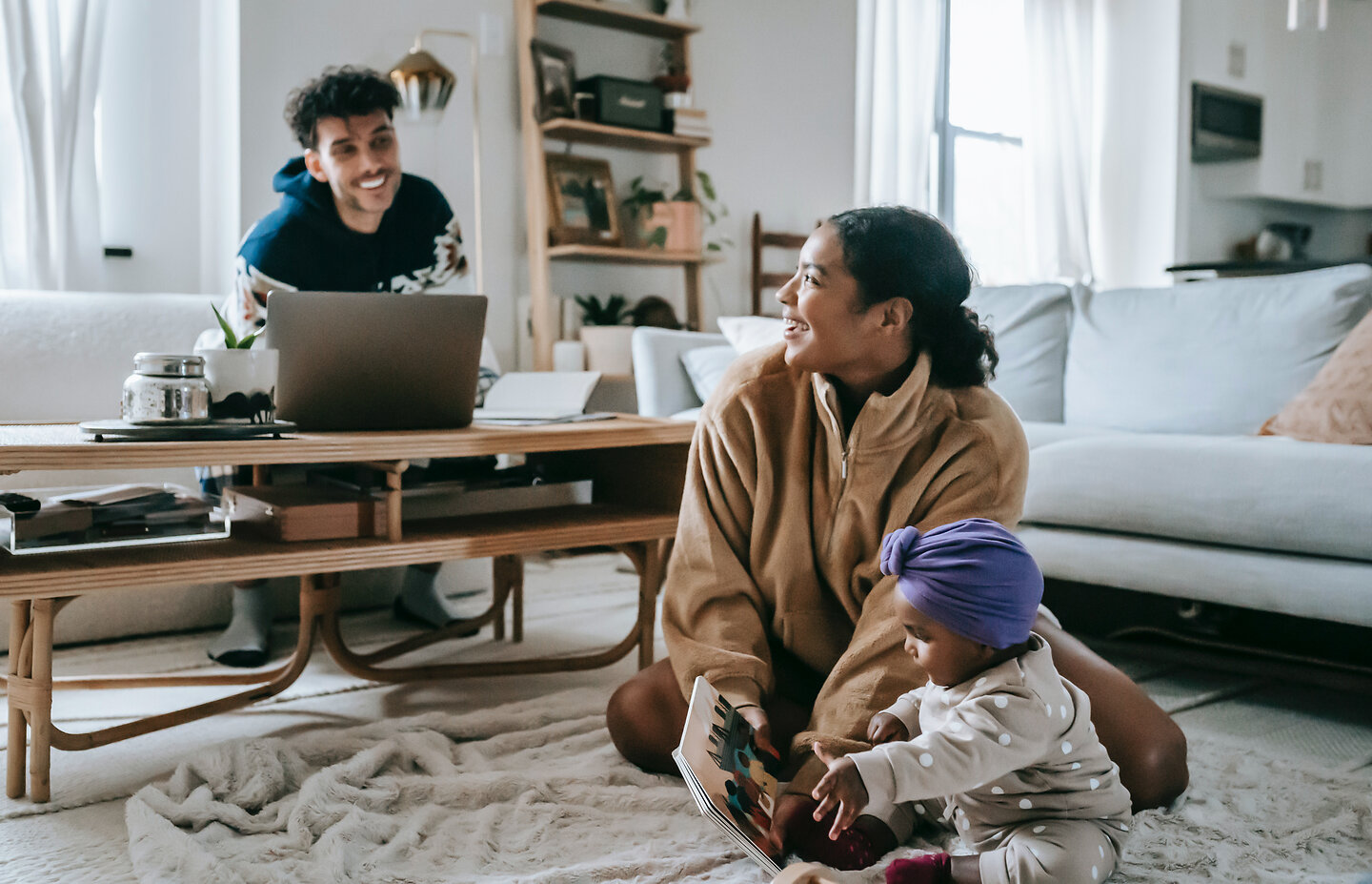 Eine dreiköpfige Familie im Wohnzimmer.