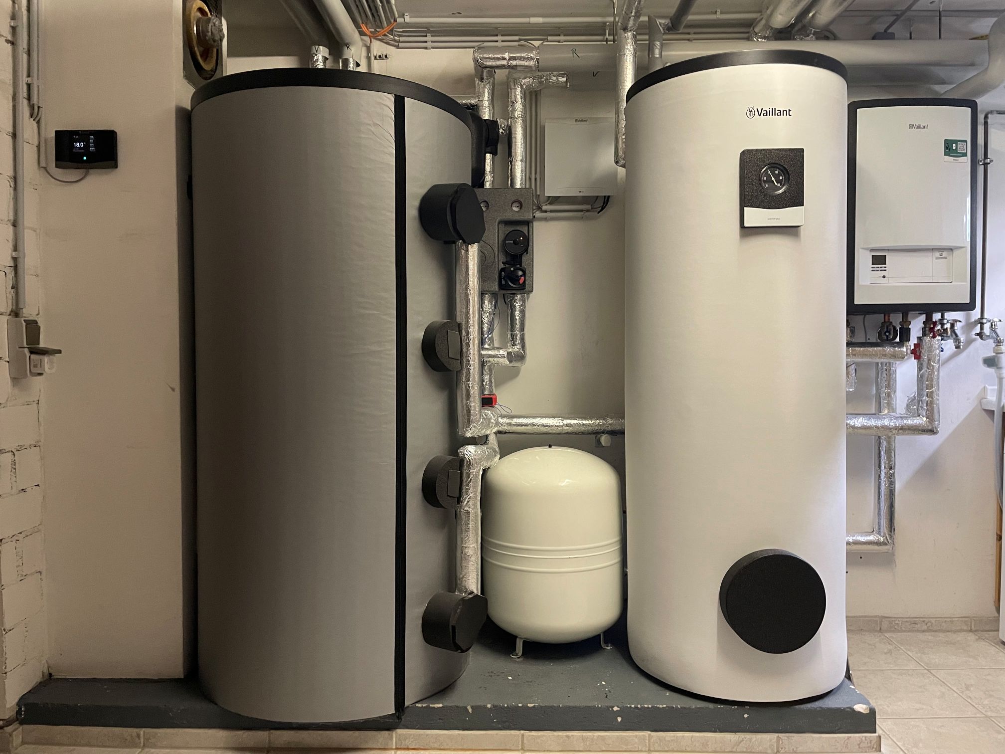 Blick in einen modernen Heizungskeller mit Wärmepumpe und Pufferspeicher