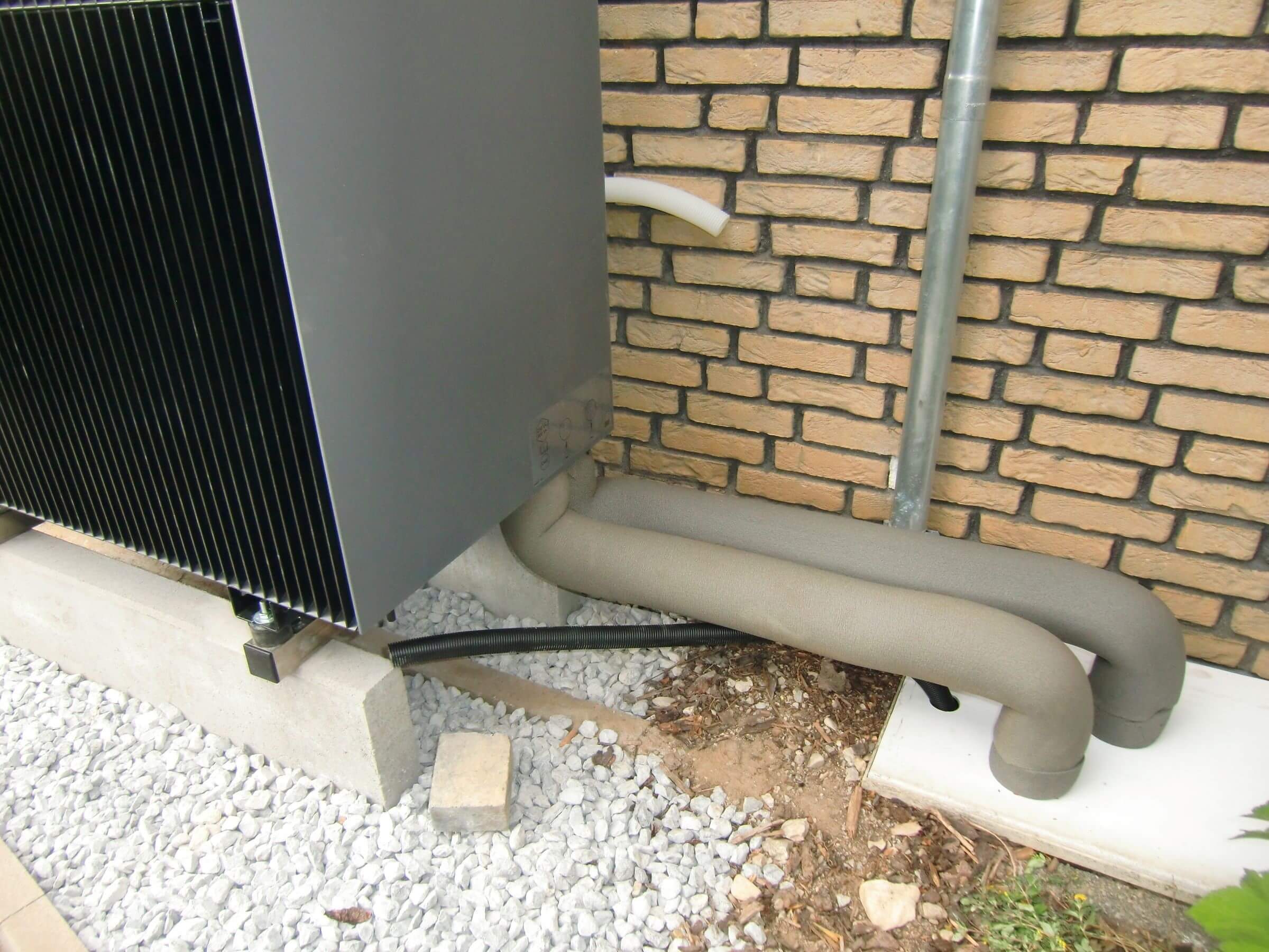 Anschlussrohre der Wärmepumpe, die ins Hausinnere führen
