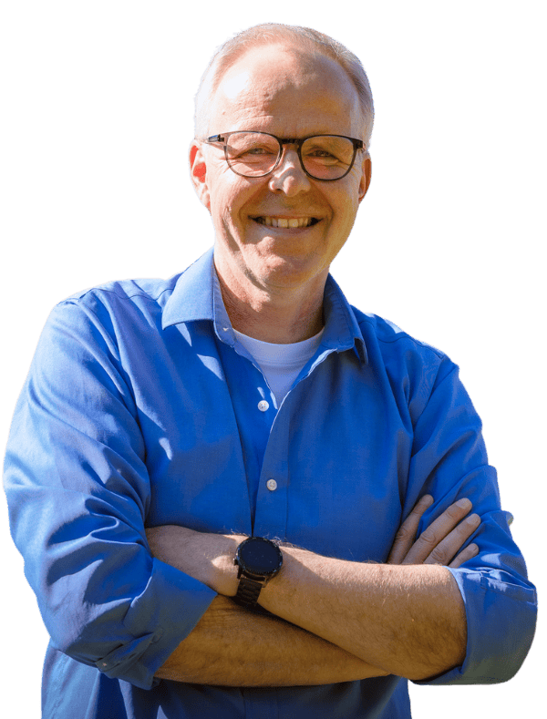 Kai B. mit Brille und blauem Hemd lächelt mit verschränkten Armen in die Kamera