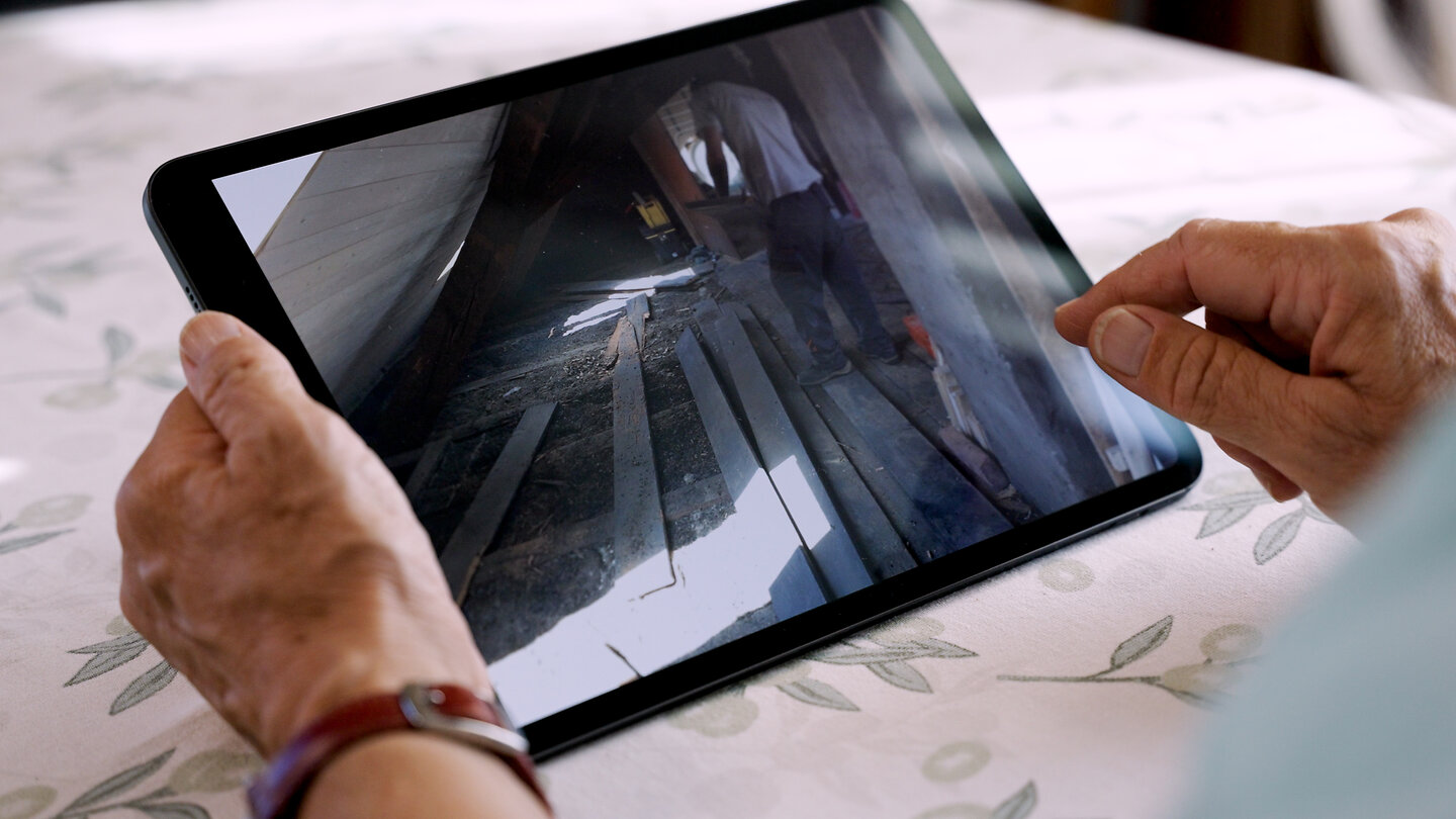 Cornelia zeigt auf dem Tablet Bilder von der Baustelle