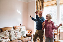 Senioren-Paar tanzt im Eigenheim.