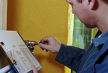 Ein Handwerker nimmt einen hydraulischen Abgleich vor, in dem er die Thermostatventile voreinstellt.