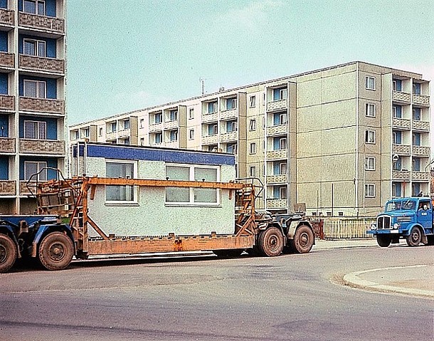 Serielles Bauen 1975 in Karl-Marx-Stadt, heute Chemnitz (Transport von Großtafeln/Fassaden-Modulen per Lkw, im Hintergrund ein Plattenbau).