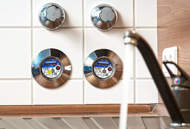 Warmwasserzähler und Kaltwasserzähler in der Küche messen direkt, wie viel warmes Wasser durch das Rohr fließt.