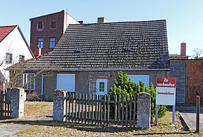 Altes Haus mit Verkaufen-Schild