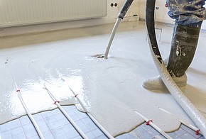 Foto einer Fußbodenheizung, die in Estrich eingeschlossen wird.