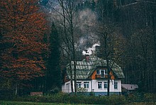 Ein Haus mit Schornstein, aus dem Rauch steigt.