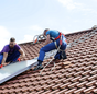 Installation Solarthermie: Männer schieben Kollektor übers Dach